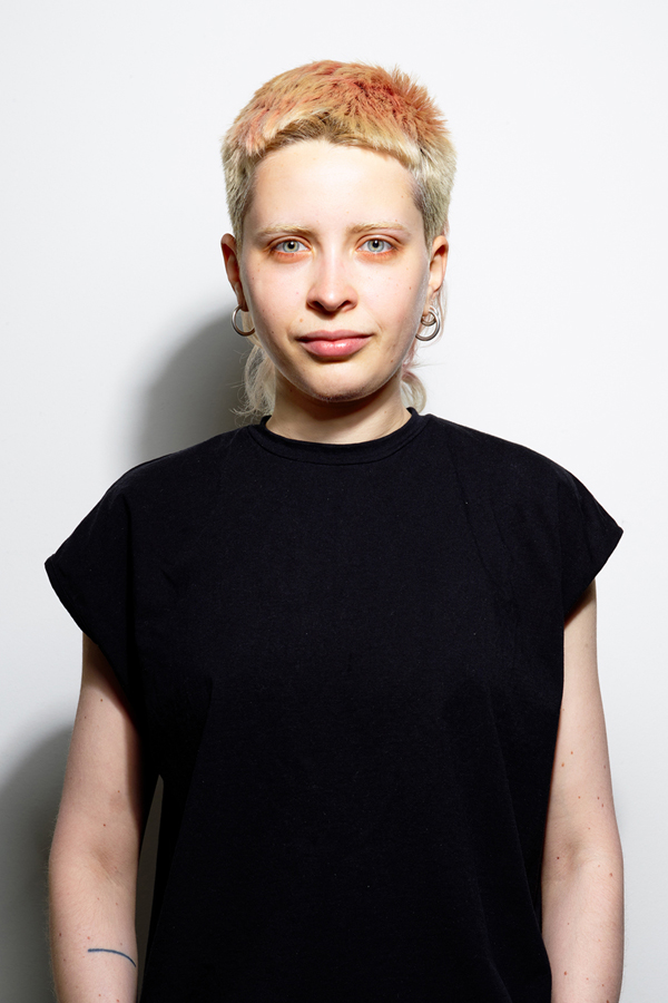 Staff photo of Anna Semenova. Anna is wearing a black T-shirt and standing in front of a white wall.