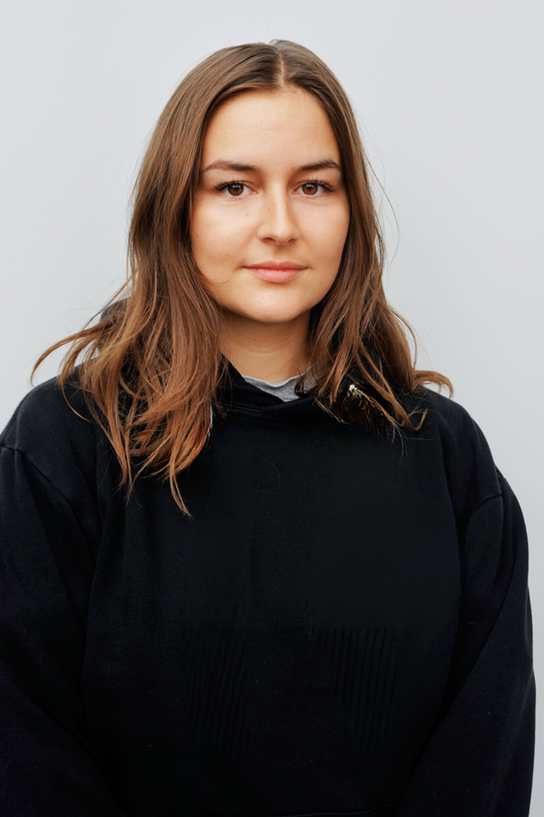 Staff photo of Anna-Lena Salfer. She is wearing a black sweater and standing in front of a white wall.