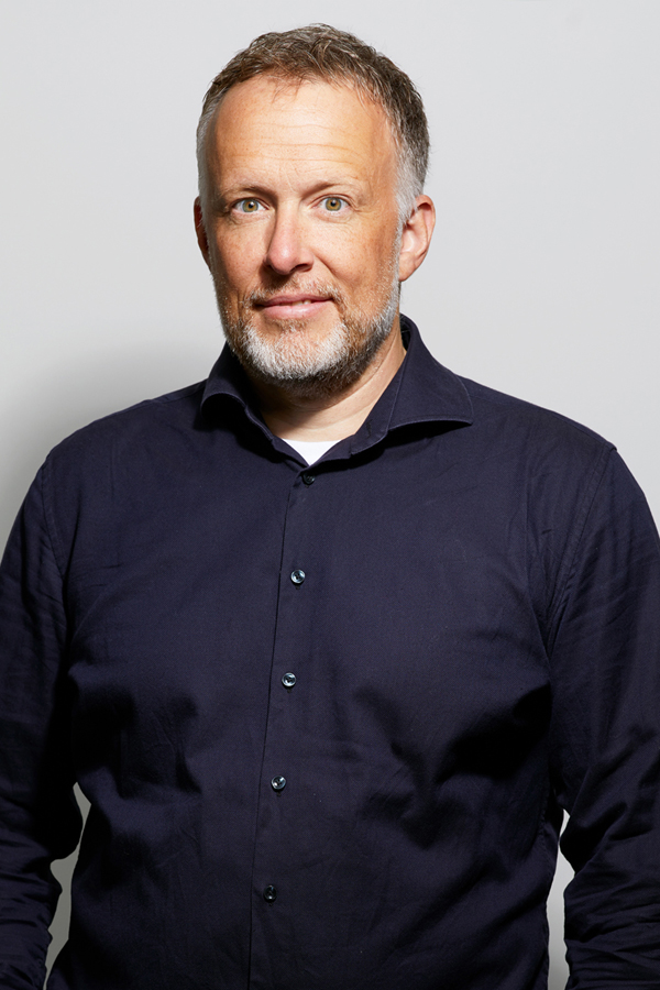 Employee photo of Thorsten Wetzling. He wears a blue shirt and stands in front of a white wall.