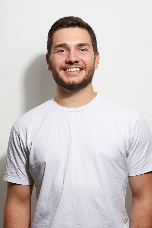 Employee photo of Frederic Dutke. He wears a white T-shirt and stands in front of a white wall.