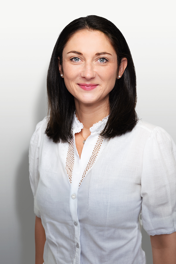 Staff photo of Anna-Laura Beyer. She wears a white blouse and stands in front of a white wall.